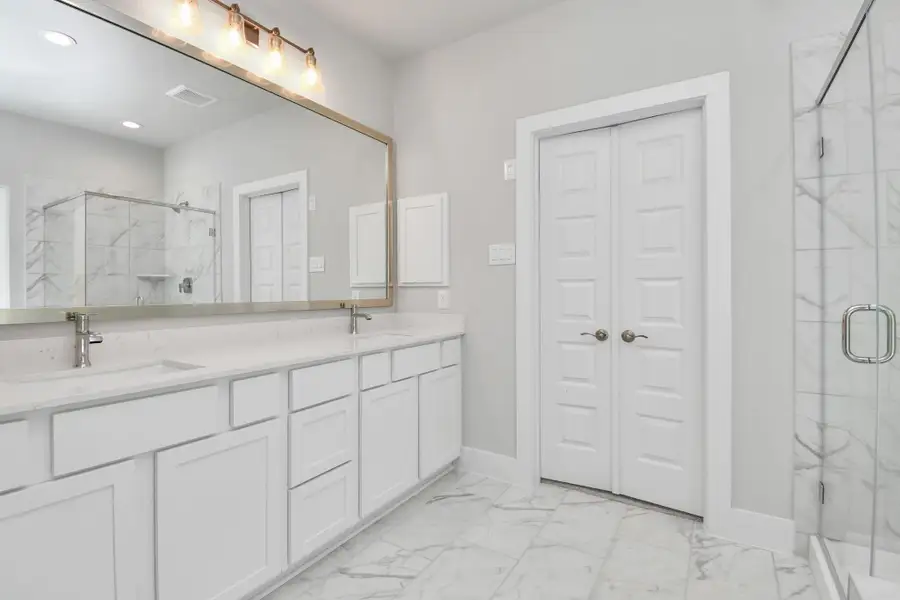 Elevate your daily routine at the elegant vanity, now equipped with double sinks, light countertops, modern hardware, and beautiful vanity lights. Sample photo of completed home with similar floor plan. Actual colors and selections may vary. Elevate your daily routine at the elegant vanity, now equipped with double sinks, light countertops, modern hardware, and beautiful vanity lights. Sample photo of completed home with similar floor plan. Actual colors and selections may vary.