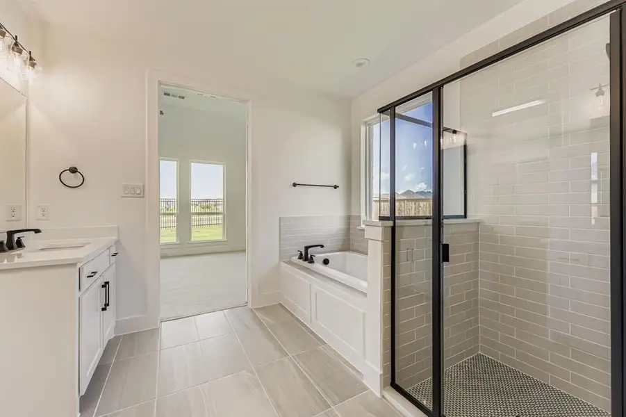 Full bath featuring vanity, a stall shower, a bath, and healthy amount of natural light