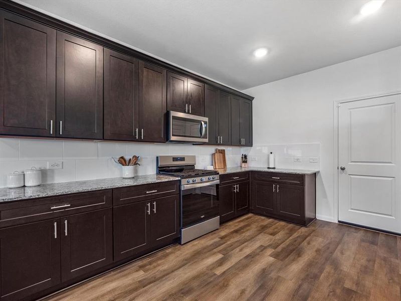 Ample cabinetry with added hardware, ample storage and an abundance of granite surface area!