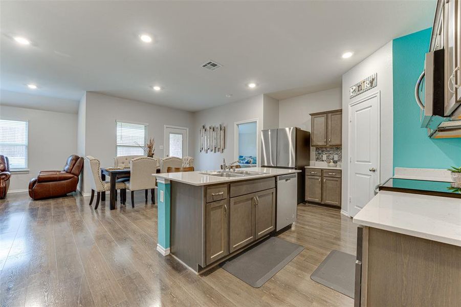 Kitchen with plenty of natural light, sink, a kitchen island with sink, and stainless steel appliances