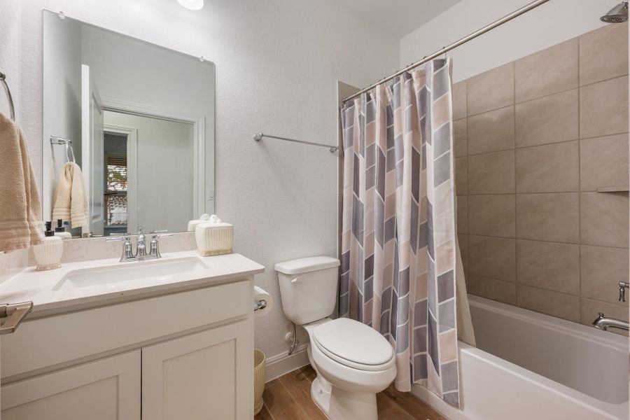 A pristine full bathroom, featuring elegant tile work and practical fixtures. A pristine full bathroom, featuring elegant tile work and practical fixtures.