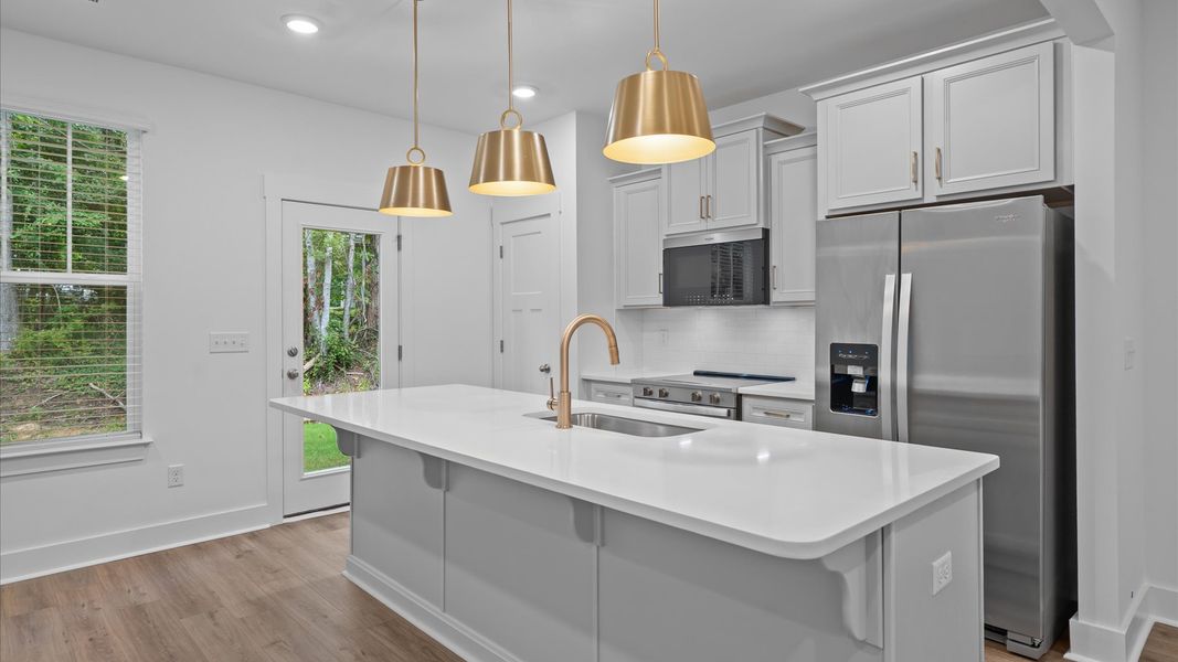 Exclusive DRB Homes kitchen with a 9-foot island, elevated finishes, and pendant lighting in a prime location Exclusive DRB Homes kitchen with a 9-foot island, elevated finishes, and pendant lighting in a prime location