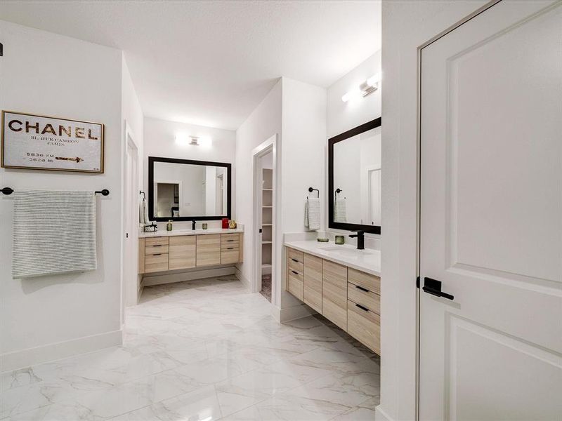 Bathroom featuring two vanities and light marble finish floors Bathroom featuring two vanities and light marble finish floors