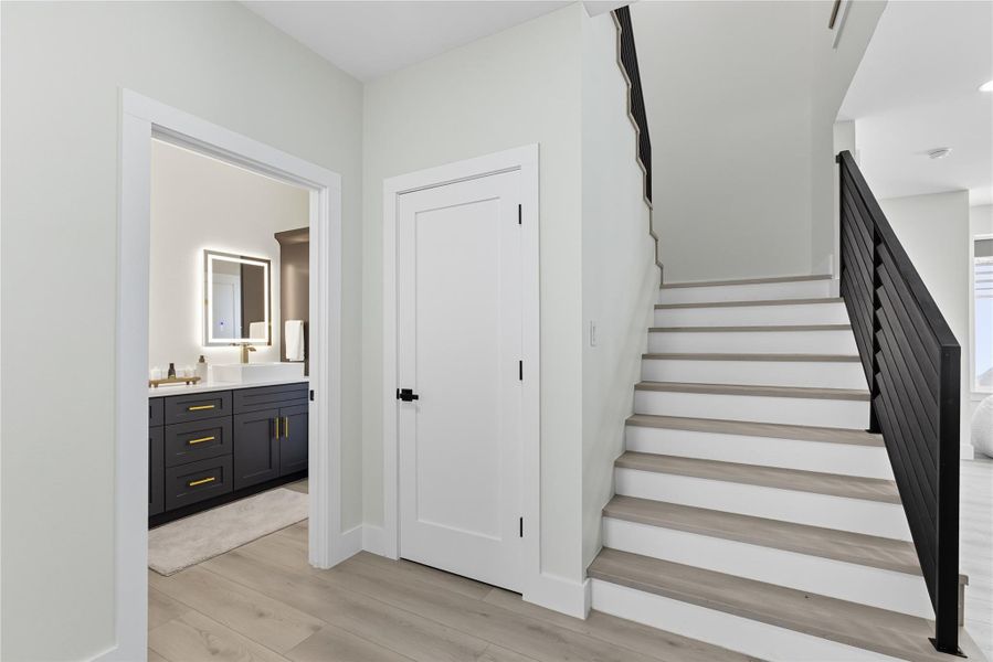 Stairway with wood finished floors and baseboards
