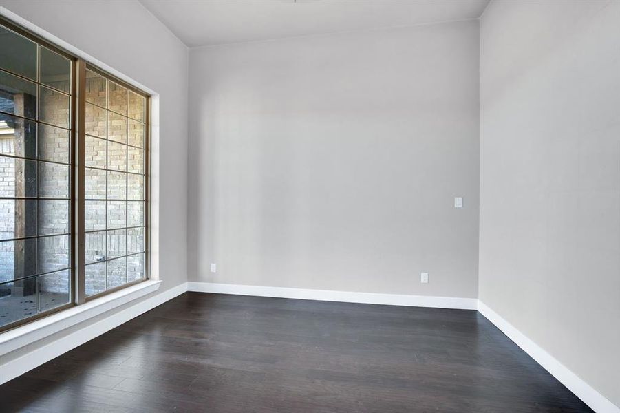 Unfurnished room with dark wood-type flooring