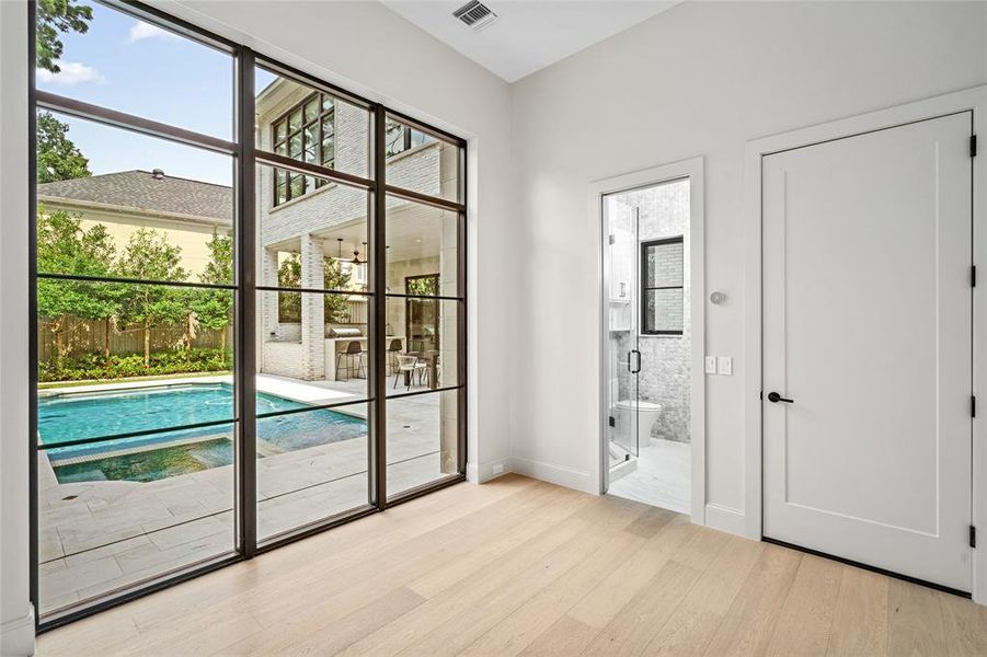 The first-floor flex space is a versatile gem, featuring gleaming white oak hardwood floors and a wall of windows that frame breathtaking views of the stunning backyard. Complete with an ensuite bathroom, this space is perfect for a workout area or could easily be transformed into a charming sixth bedroom.