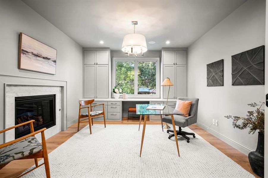 Office with light hardwood / wood-style flooring and a fireplace