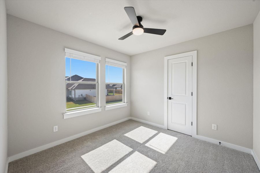 Plentiful natural light streams across the carpeted floor through large windows. Plentiful natural light streams across the carpeted floor through large windows.