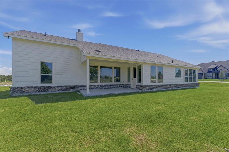 Exterior featuring light-colored siding and a dark shingle roof