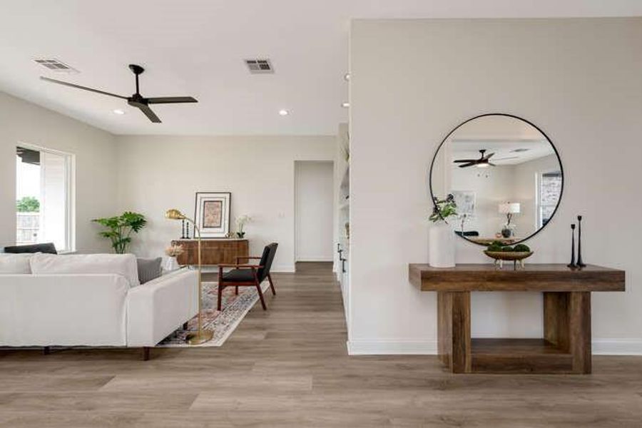 Living room featuring ceiling fan, light wood-style floors, and recessed lighting Living room featuring ceiling fan, light wood-style floors, and recessed lighting