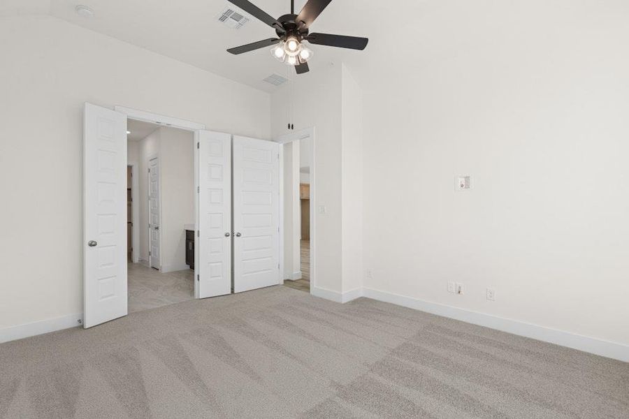 Unfurnished bedroom with light colored carpet, a ceiling fan, and ensuite bathroom Unfurnished bedroom with light colored carpet, a ceiling fan, and ensuite bathroom