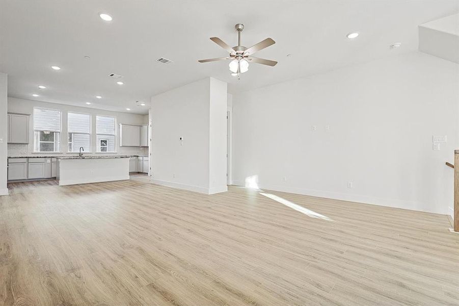 Unfurnished living room with light wood-style flooring, recessed lighting, visible vents, and ceiling fan