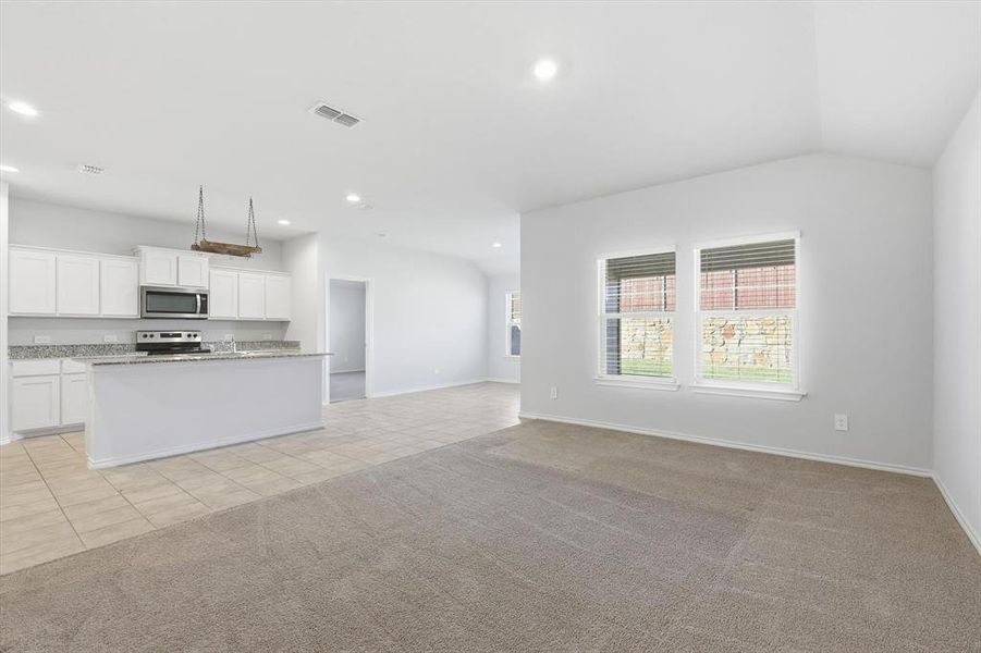 Living area with windows, carpet and view of kitchen and dining Living area with windows, carpet and view of kitchen and dining