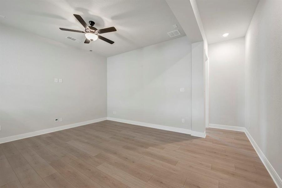 Spare room with light wood finished floors, ceiling fan, and recessed lighting