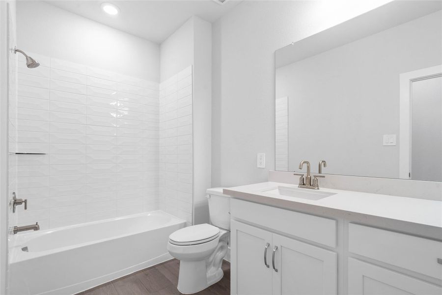A streamlined secondary bathroom providing a functional tub/shower combination, vanity with modern fixtures seamlessly blending practicality and style.