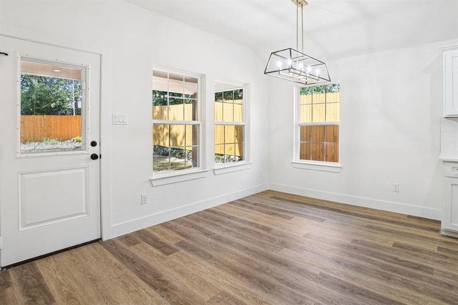Unfurnished dining area with wood finished floors and a chandelier Unfurnished dining area with wood finished floors and a chandelier