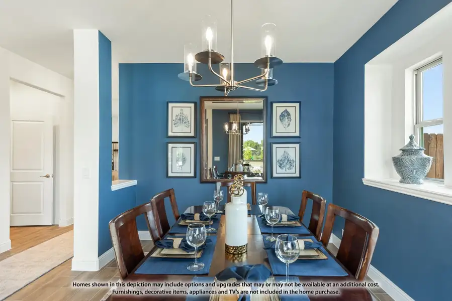 Dining room with blue walls, wood table set for six, and modern chandelier overhead Dining room with blue walls, wood table set for six, and modern chandelier overhead