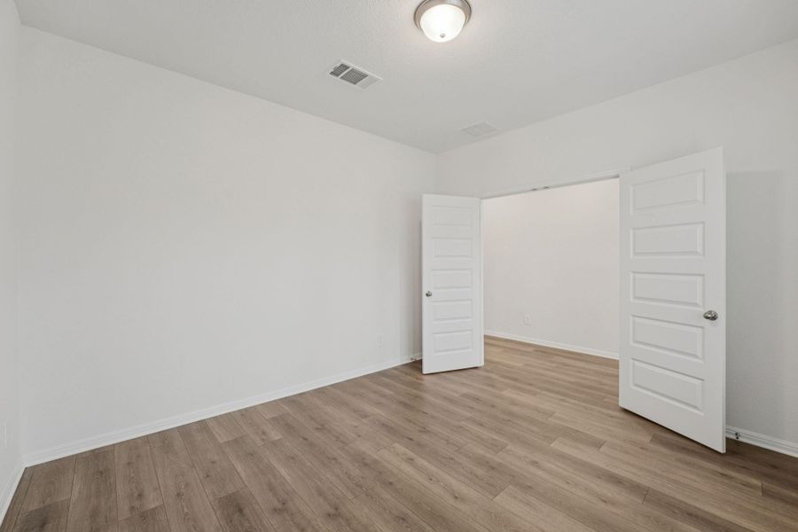 Unfurnished bedroom with light wood-style floors and baseboards