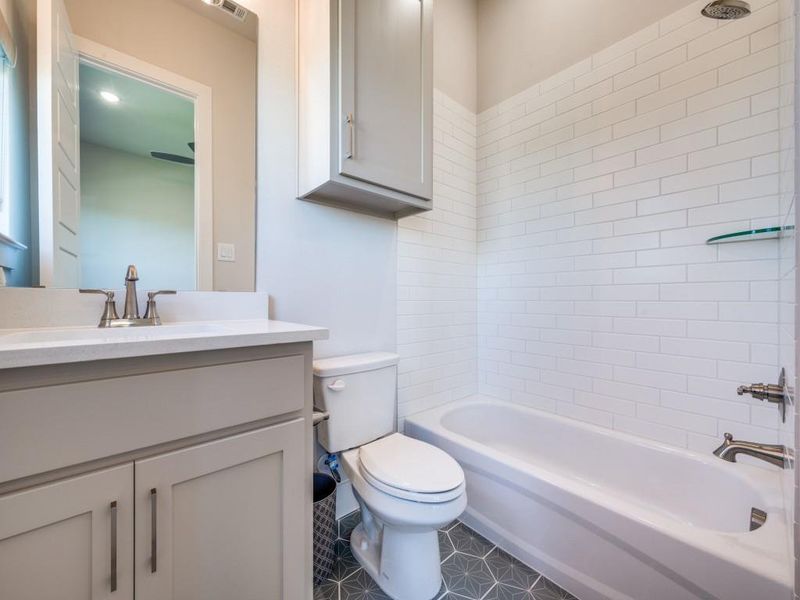 Bathroom with toilet, vanity, and tub / shower combination