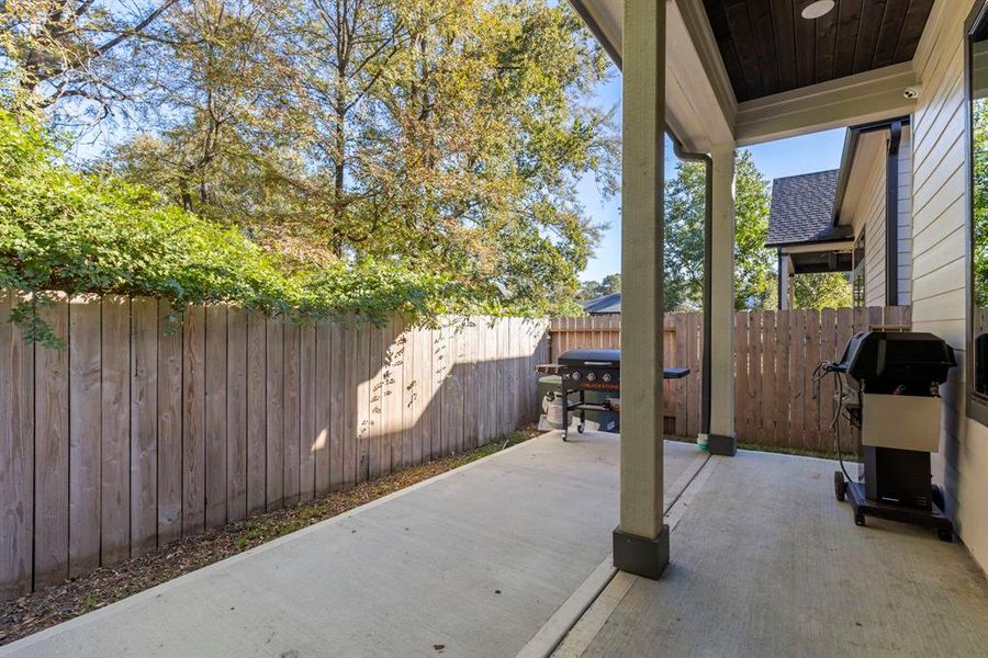 The low-maintenance backyard is designed for ease and enjoyment, featuring a covered patio and extended concrete, perfect for outdoor grilling.