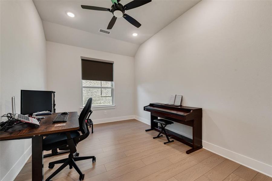 Office area with light wood finished floors, vaulted ceiling, recessed lighting, and a ceiling fan