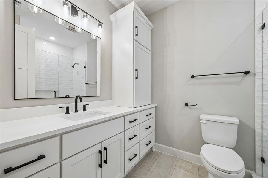 Full bathroom featuring vanity, a shower stall, and light tile patterned flooring Full bathroom featuring vanity, a shower stall, and light tile patterned flooring