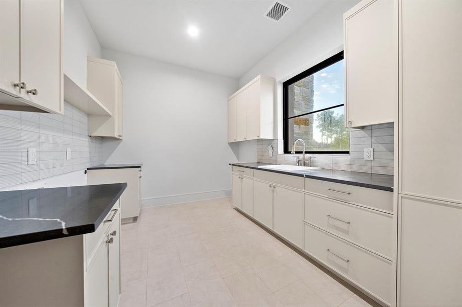 Utility room has tons of counter top and storage.