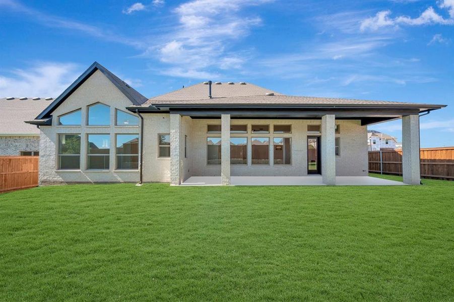 Expansive backyard featuring a manicured lawn, a covered patio, and a privacy fence Expansive backyard featuring a manicured lawn, a covered patio, and a privacy fence