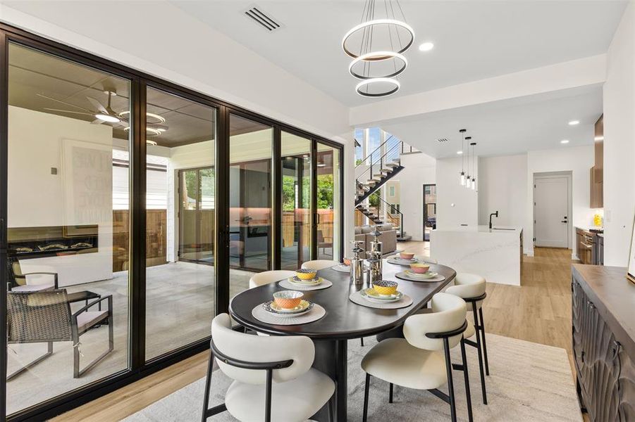 Dining area featuring wood-finish flooring and a contemporary chandelier