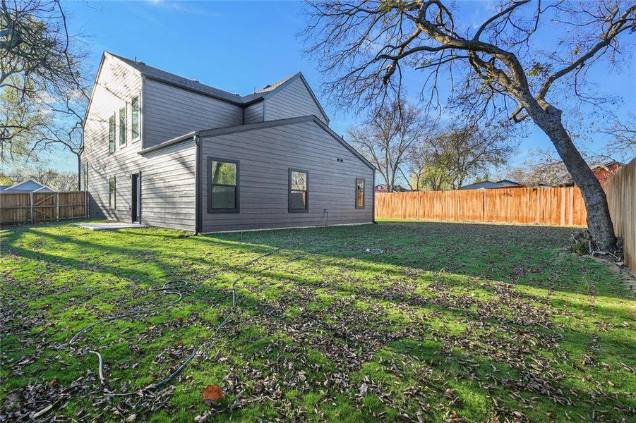 Rear view of house featuring a fenced backyard