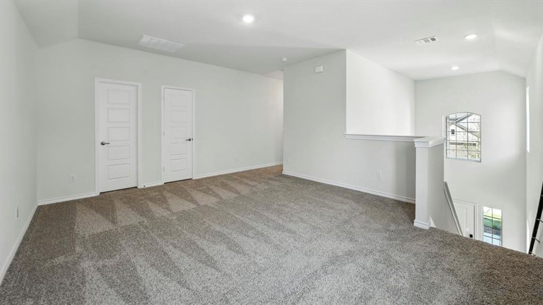 Carpeted empty room with vaulted ceiling and recessed lighting Carpeted empty room with vaulted ceiling and recessed lighting