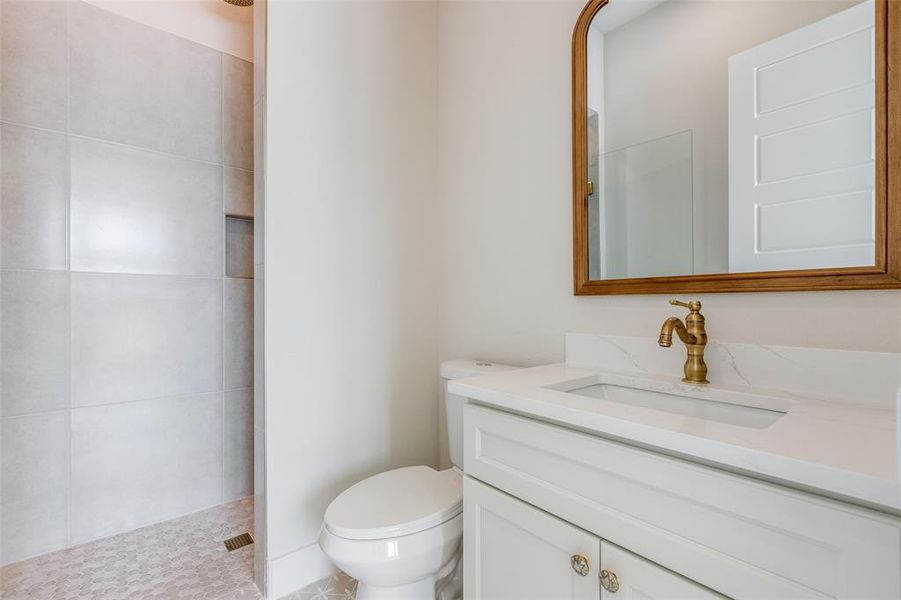 Bathroom with vanity, tile patterned floors, toilet, and a shower