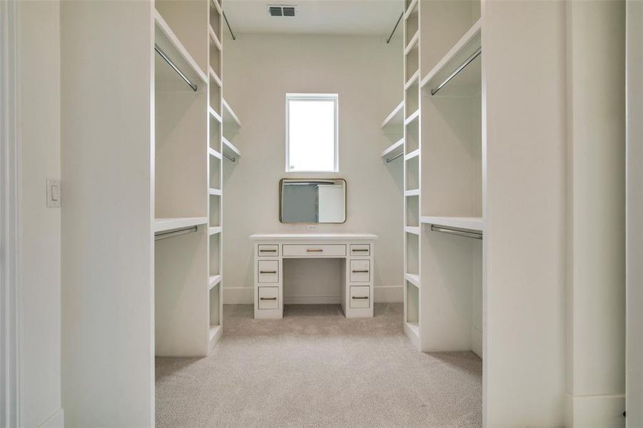 Spacious closet with carpet flooring and visible vents
