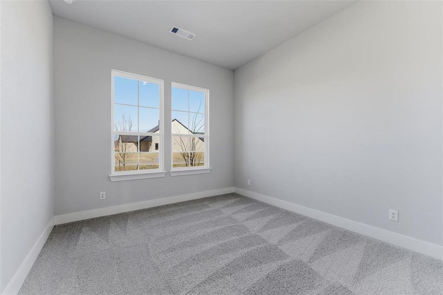 Empty room featuring baseboards and carpet
