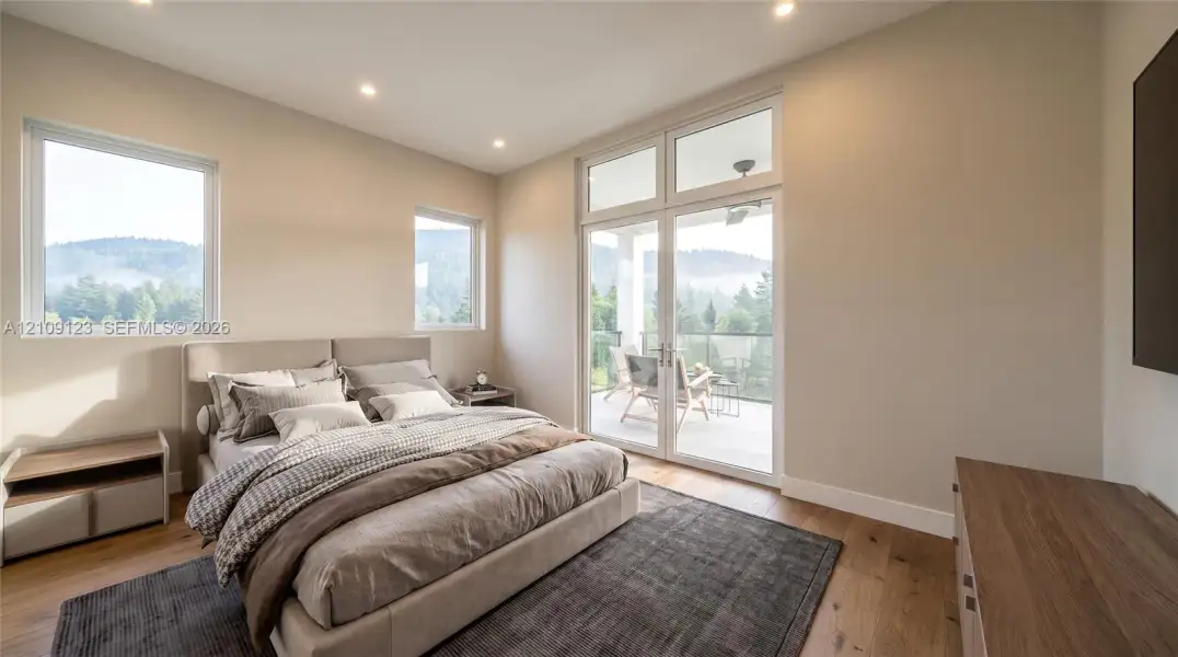 Wood-finish flooring, recessed lighting, double glass doors with transom windows, and mountain scenery Wood-finish flooring, recessed lighting, double glass doors with transom windows, and mountain scenery