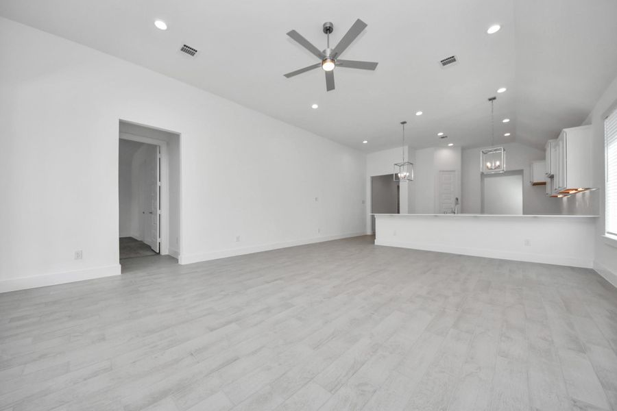 Family room flooded with natural light through the expansive windows.  The premium tile flooring adds a touch of luxury to the space, creating the perfect setting for relaxing moments and cherished gatherings with loved ones.