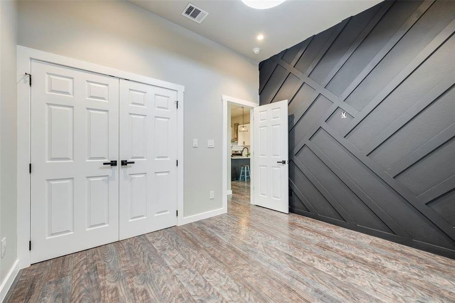 Unfurnished bedroom with wood finished floors and a closet