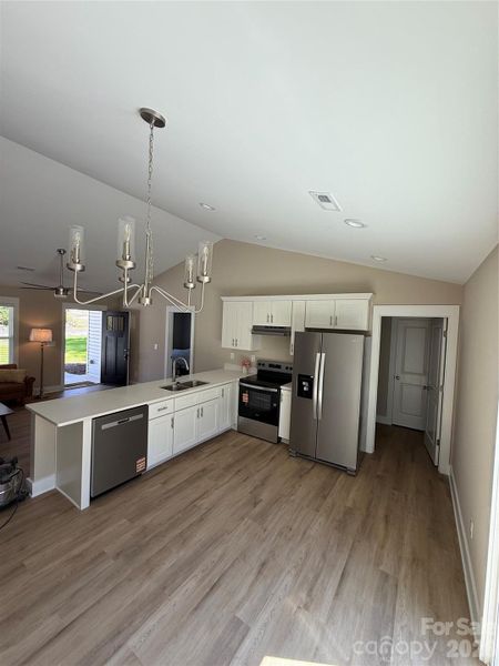 Kitchen from dining area showing pantry/laundry on right door to Primary bedroom on left