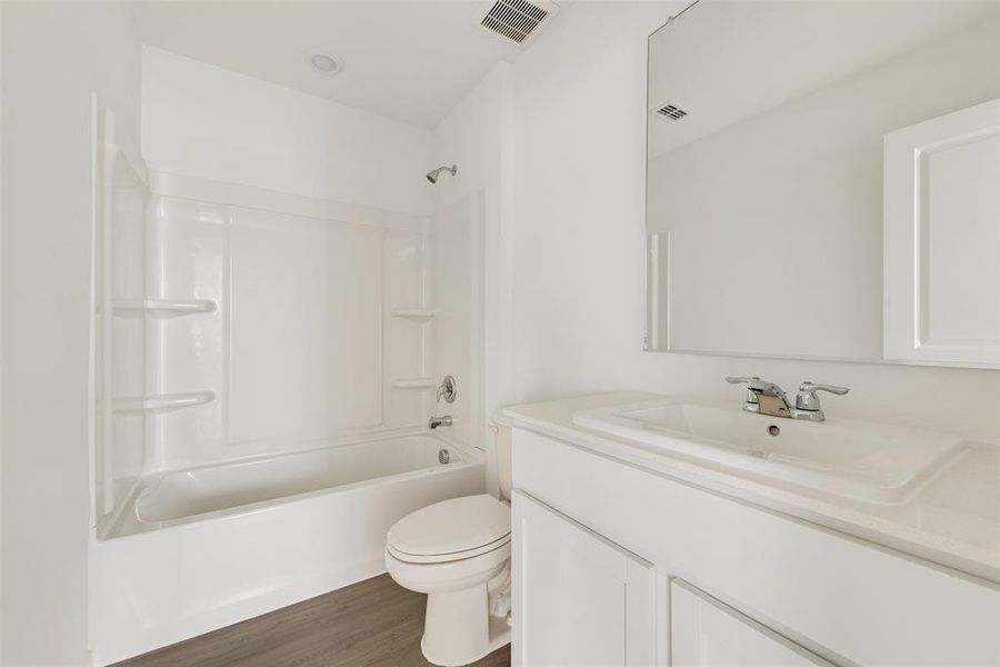 Full bathroom featuring shower / bathing tub combination, vanity, toilet, and hardwood / wood-style floors