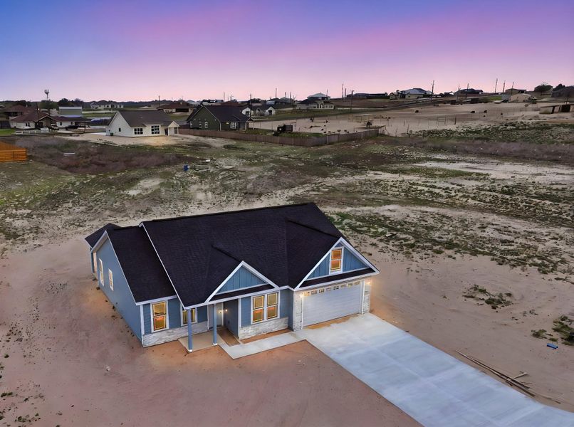 Front exterior of a new home in Las Palomas Country Club Estates, La Vernia, TX, highlighting curb appeal (Image 18).