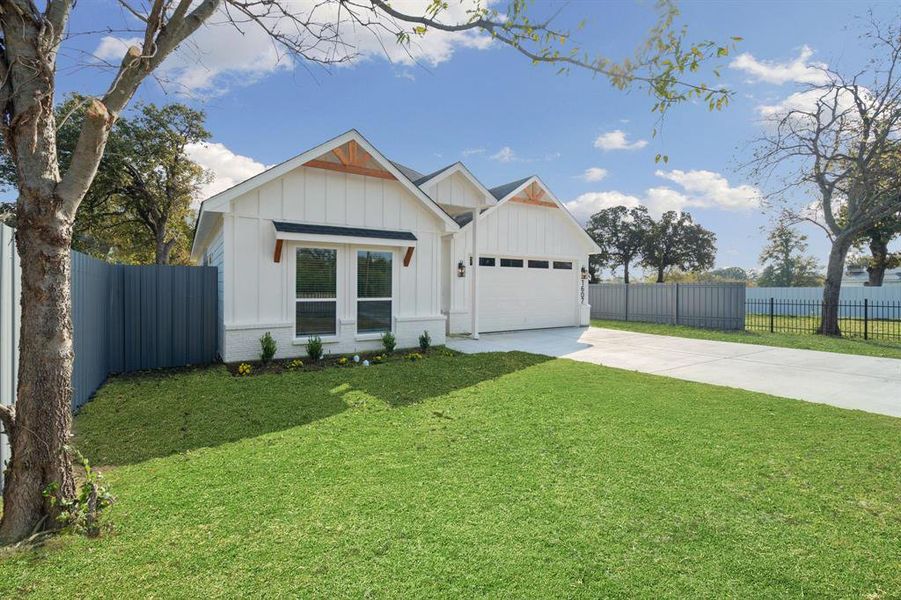 Modern farmhouse style home featuring board and batten siding, driveway, and a garage