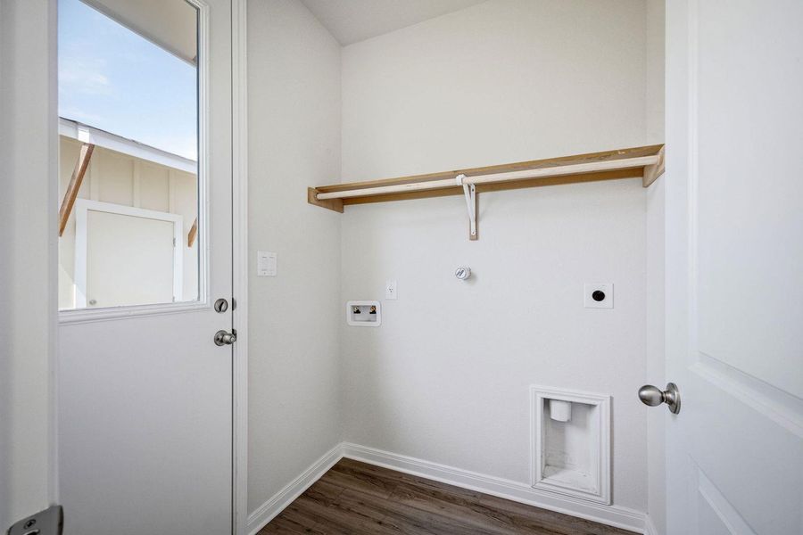 Functional utility space includes overhead storage shelves and clean vinyl plank flooring. Functional utility space includes overhead storage shelves and clean vinyl plank flooring.