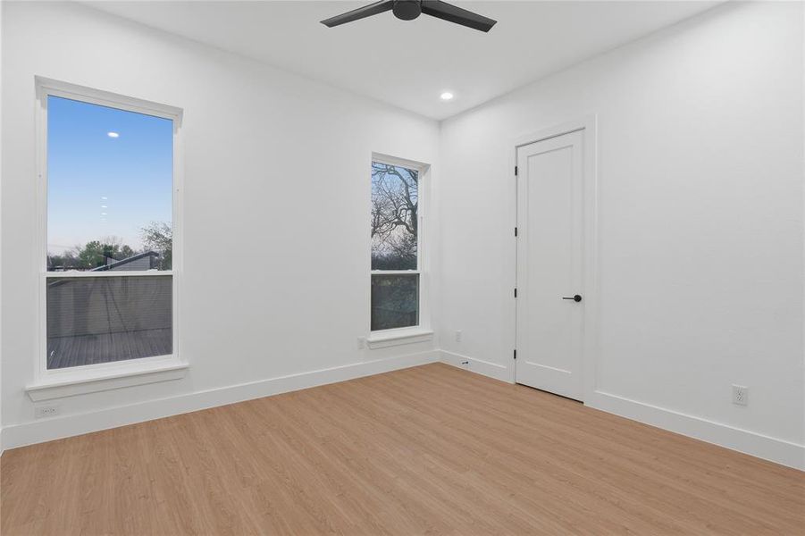 Spare room featuring light wood-style flooring, ceiling fan, and recessed lighting