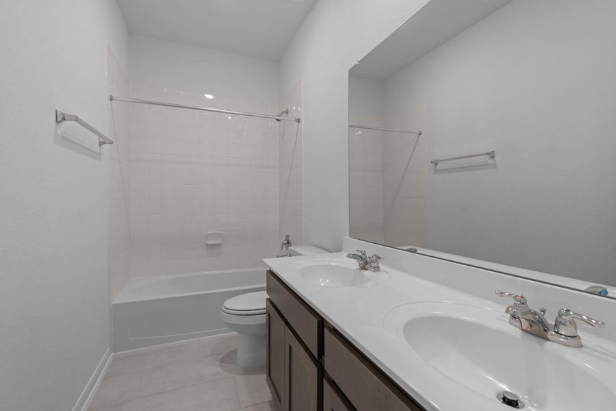 The secondary bath features tile flooring, white cabinetry and light countertops and a shower/tub combo. Perfect for accommodating any visiting family and friends. The secondary bath features tile flooring, white cabinetry and light countertops and a shower/tub combo. Perfect for accommodating any visiting family and friends.
