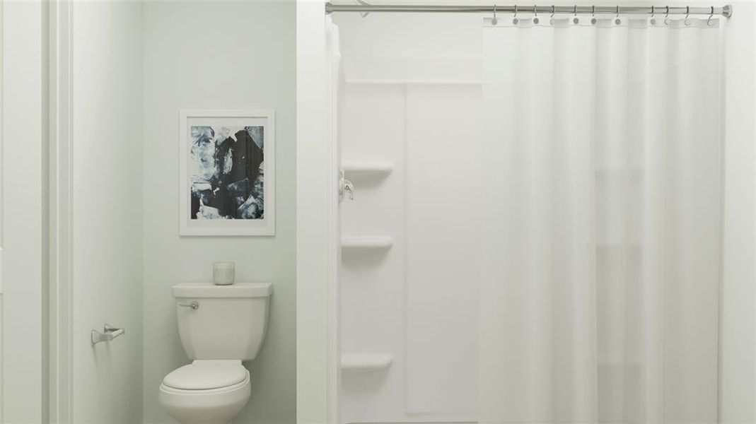 Bathroom with a shower with shower curtain and toilet