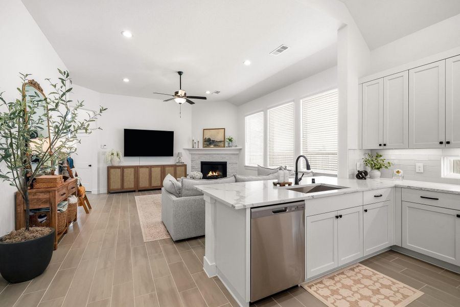 The kitchen pairs everyday convenience with refined functionality, featuring a well-positioned sink and GE stainless steel dishwasher that make meal preparation and cleanup effortless while maintaining a clean, streamlined look.