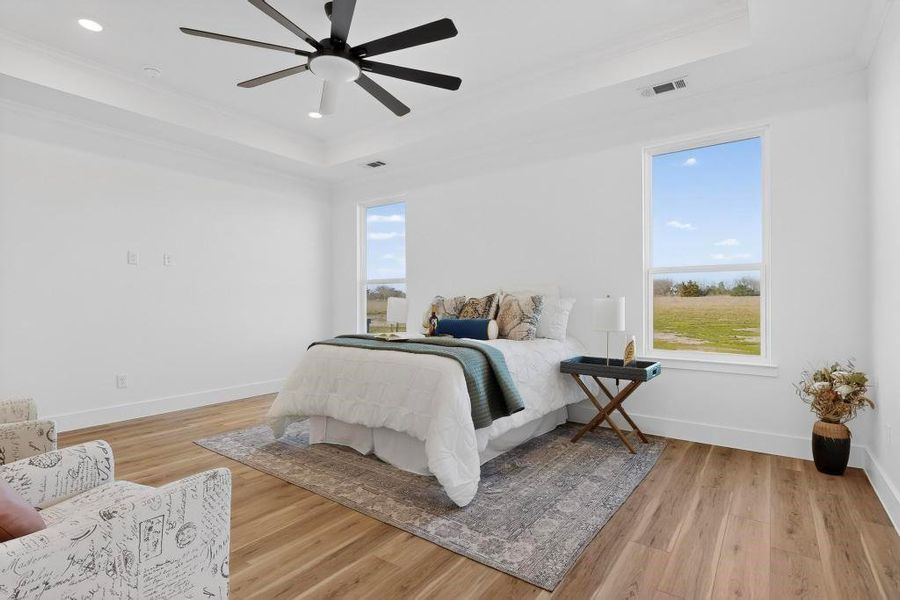 Bedroom featuring light wood-style flooring, a tray ceiling, ceiling fan, and recessed lighting Bedroom featuring light wood-style flooring, a tray ceiling, ceiling fan, and recessed lighting