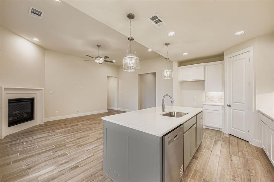 Kitchen with white cabinetry, backsplash, pendant lighting, recessed lighting, and light wood-style flooring