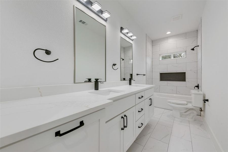 Full bath featuring double vanity, bathtub / shower combination, light marble finish flooring, and recessed lighting Full bath featuring double vanity, bathtub / shower combination, light marble finish flooring, and recessed lighting
