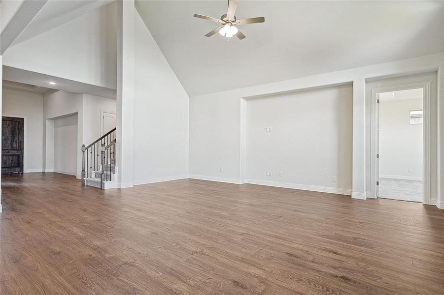 Unfurnished living room featuring high vaulted ceiling, ceiling fan, and hardwood / wood-style flooring